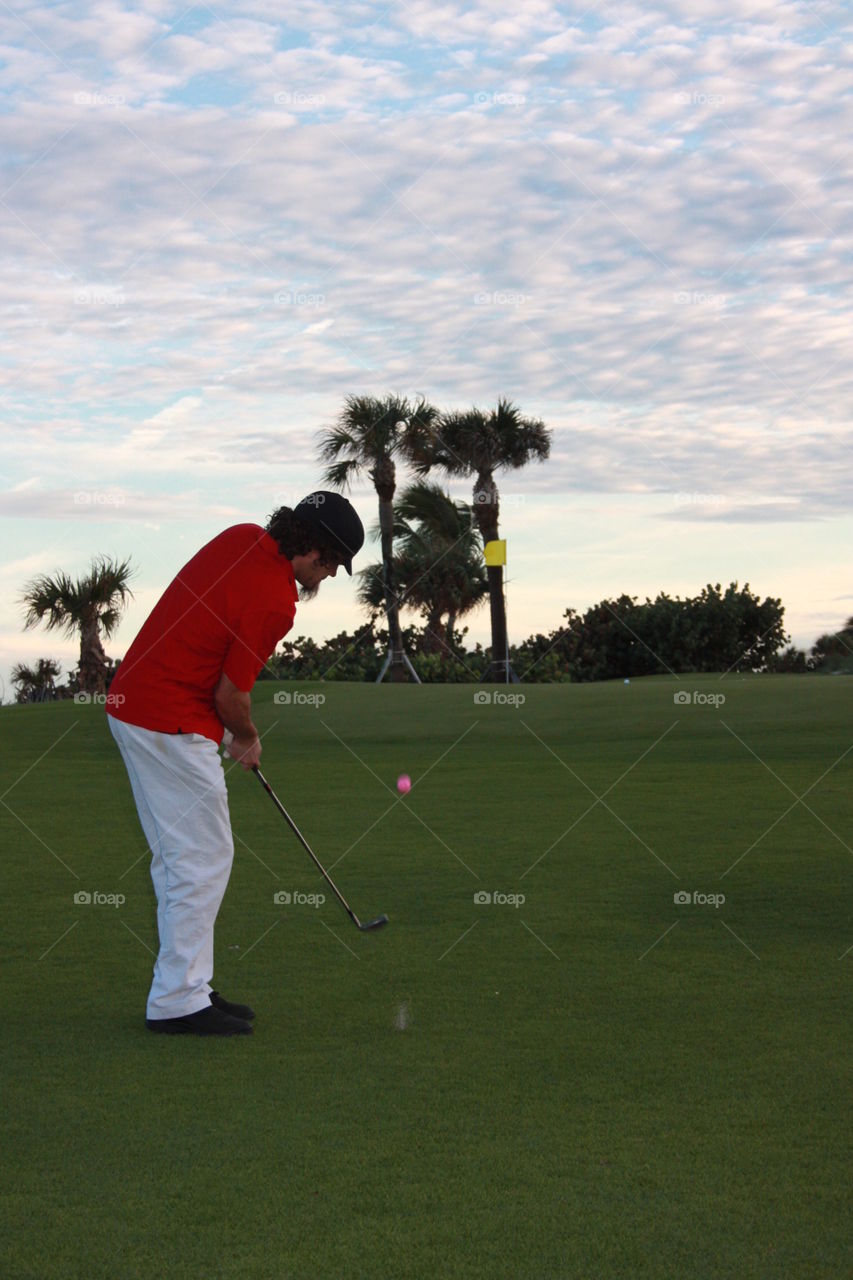 Golf. Chip shot at west palm beach par three course at sunset