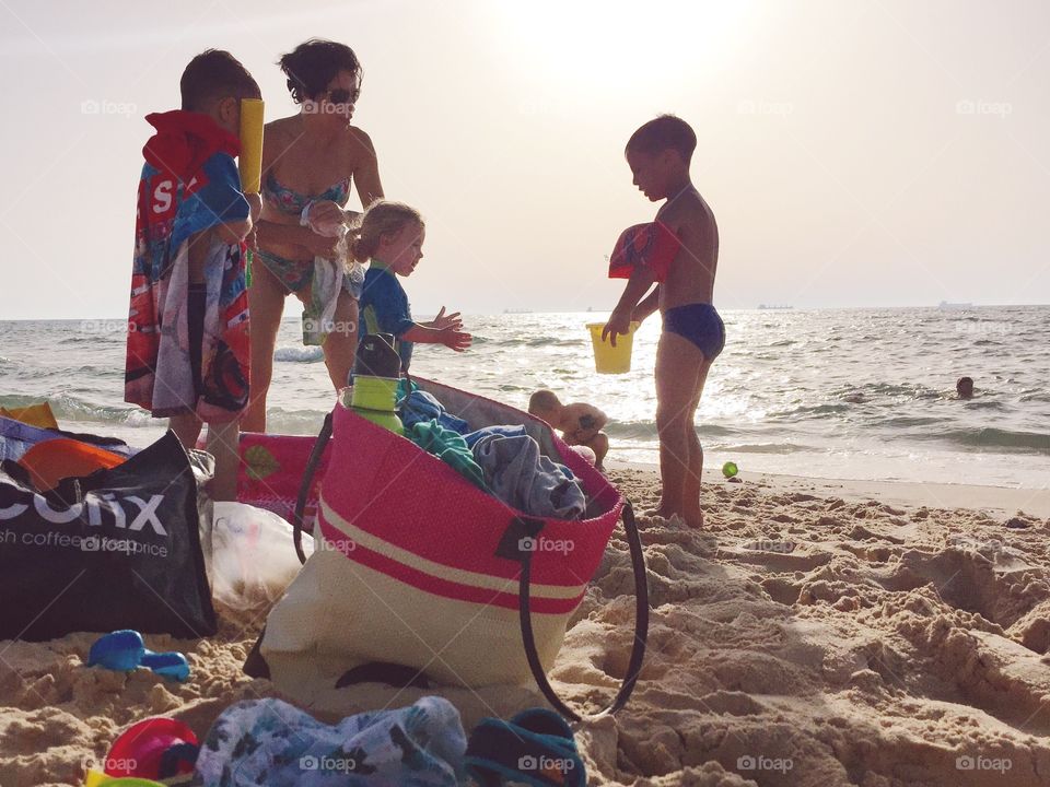 Children and mother playing in sand at beach