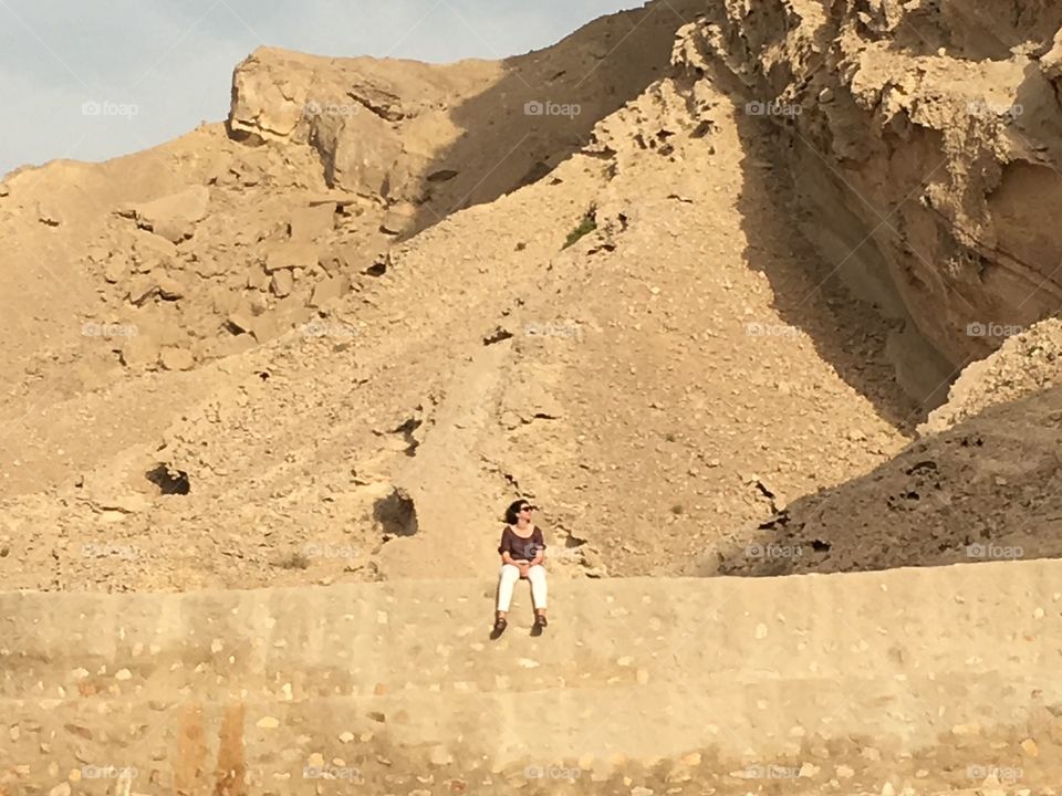 Woman on a wall in the desert 