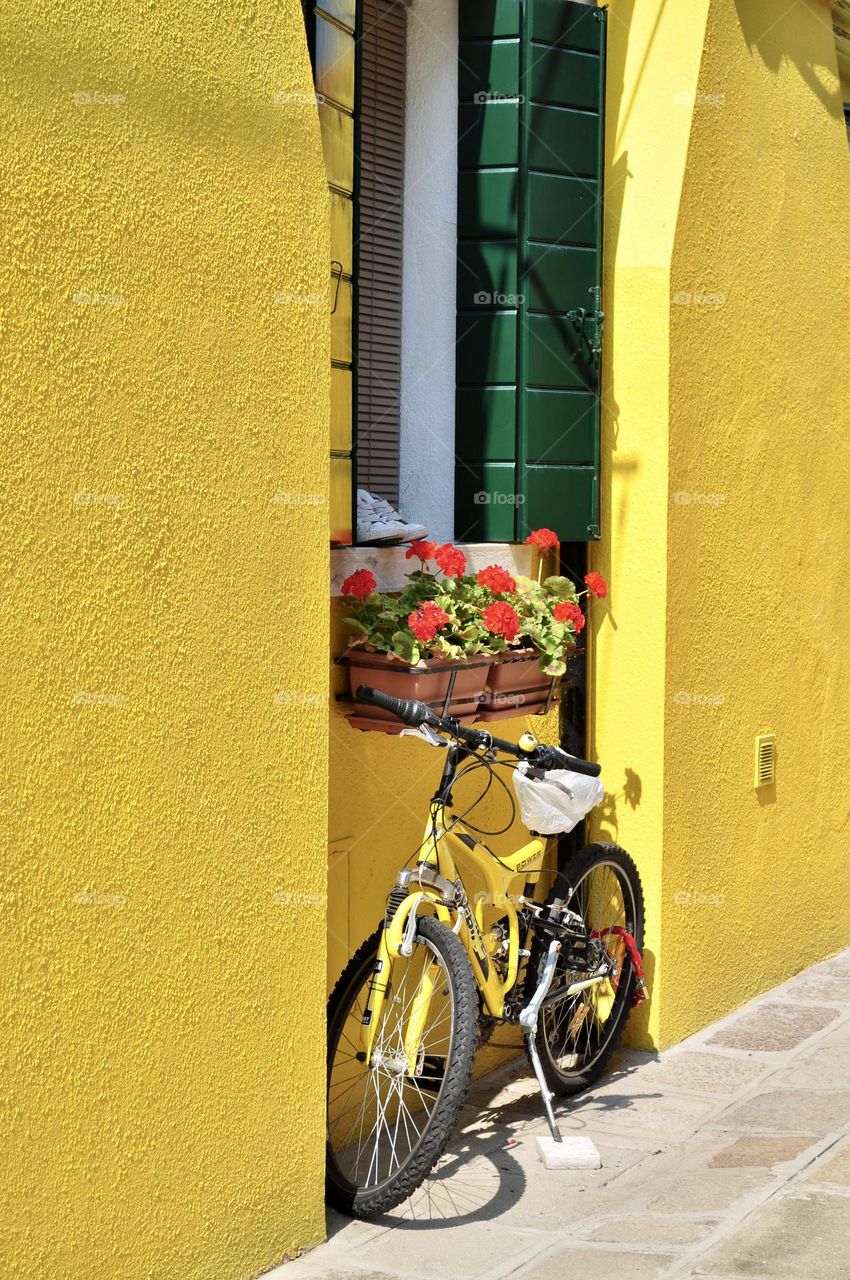 Yellow bicycle next to a yellow painted wall, yellow color, yellow nuance 