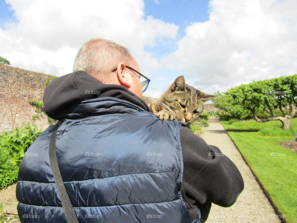 man carrying cat back to his home