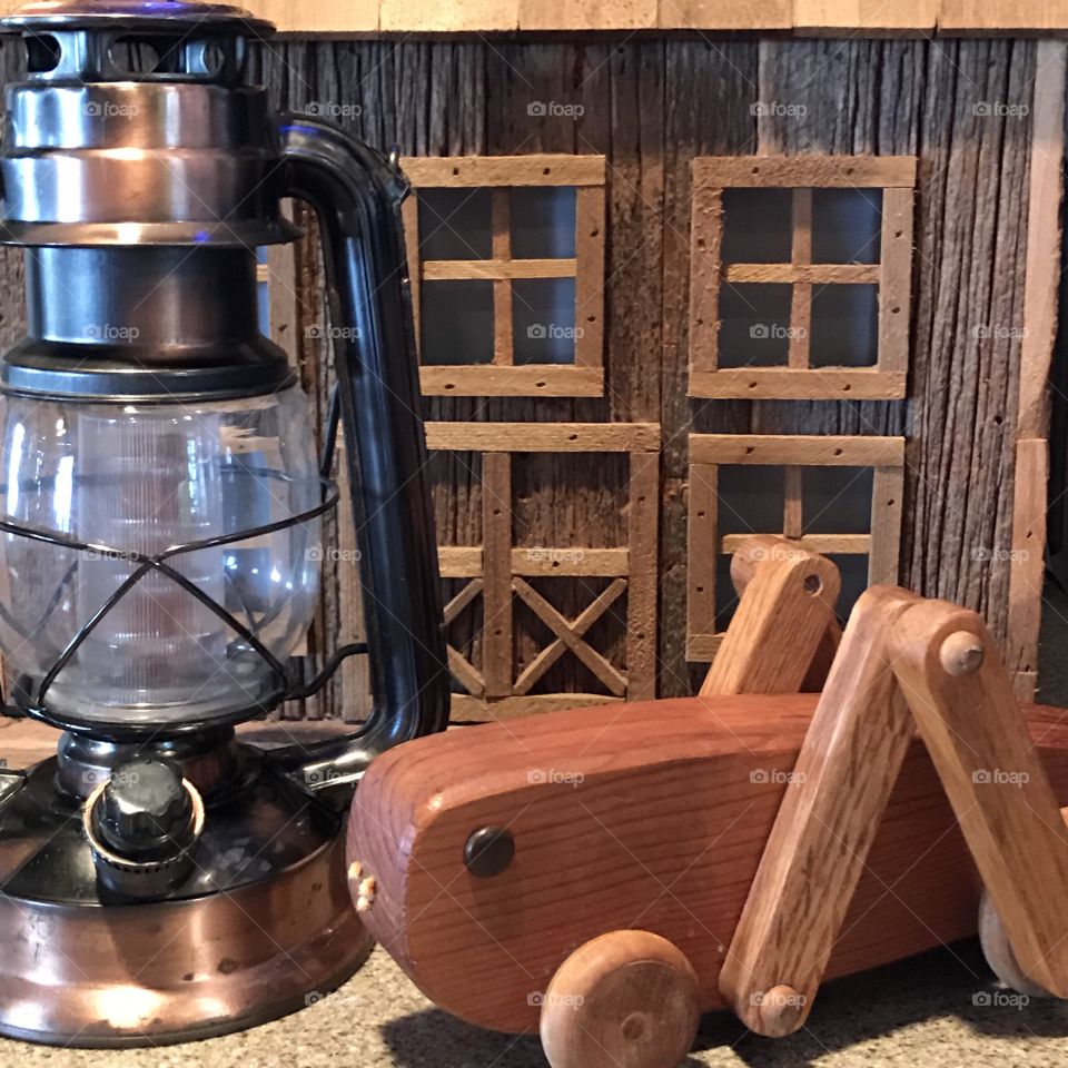 Lantern, wooden toy grasshopper and small toy barn