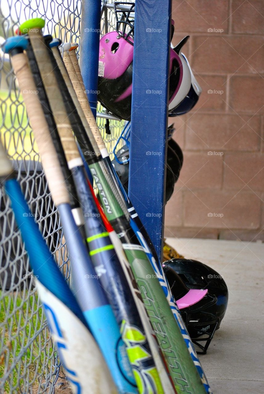 Softball bats in the dugout
