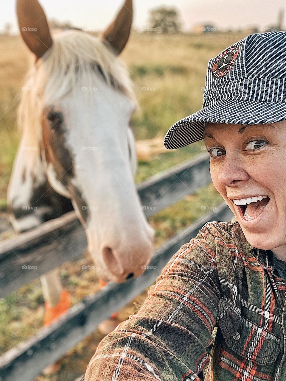 Woman takes a selfie with a horse, adventures on a horse farm, selfies with animals, having fun with horses, horsing around in the farm