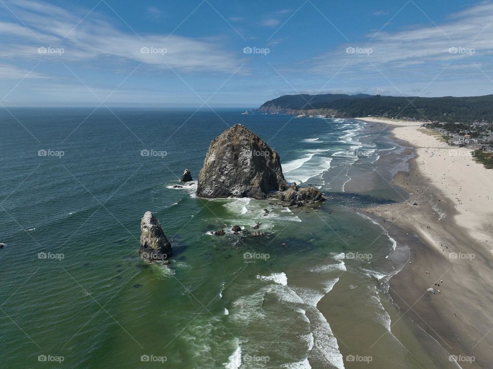 Haystack Rock standing tall amidst the serene beauty of Cannon Beach, where tide pools meet the endless horizon