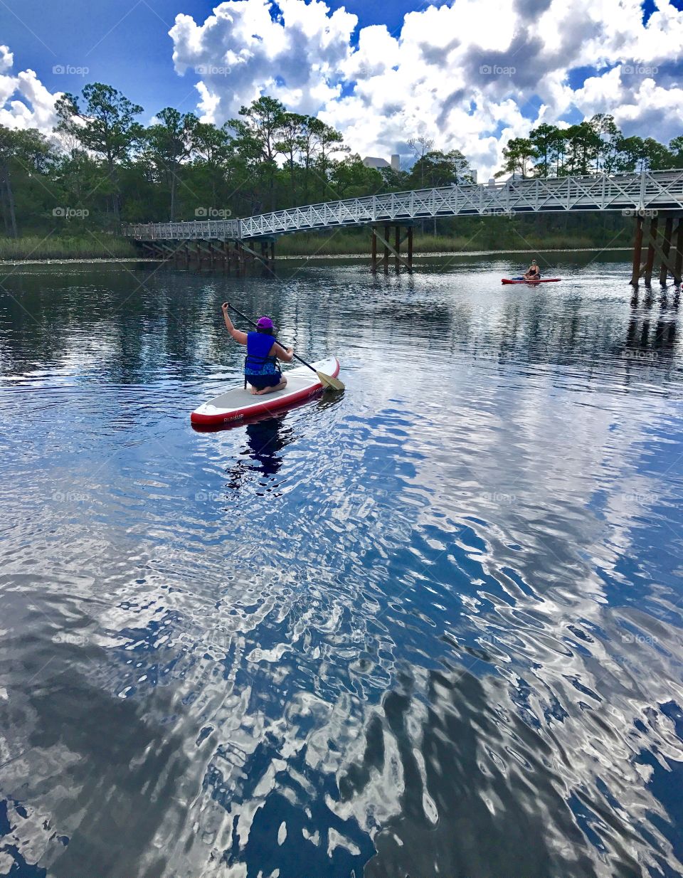 Girl paddle board to a friend 