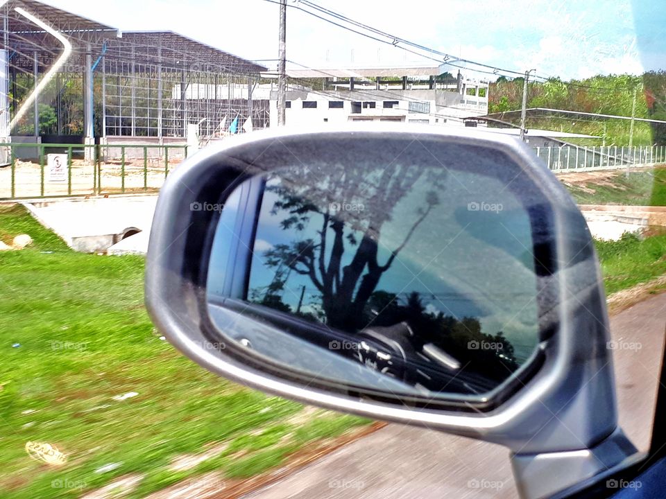 Reflection of side road view on the review mirror