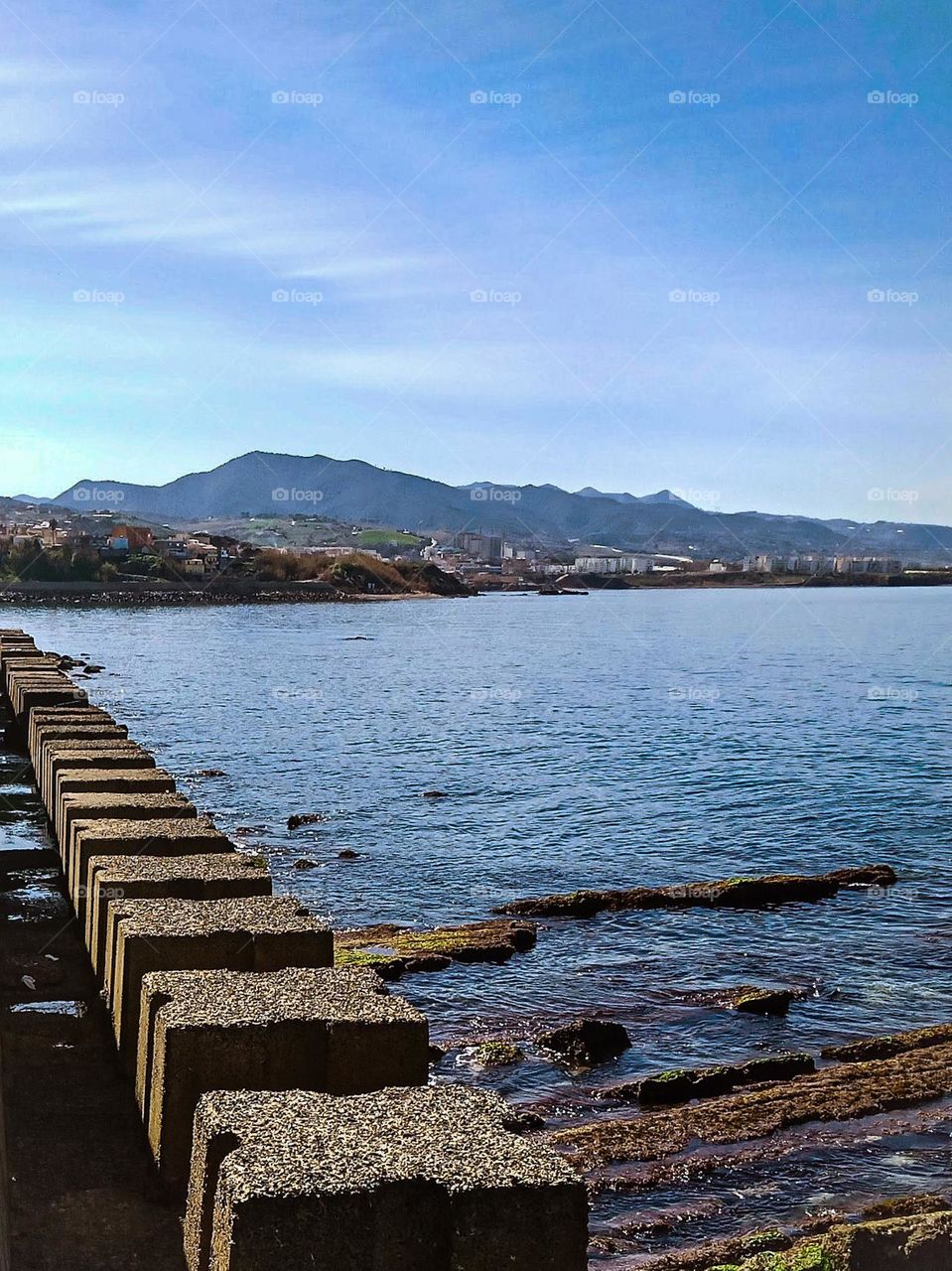 several squared-shape rocks aligned along a bay