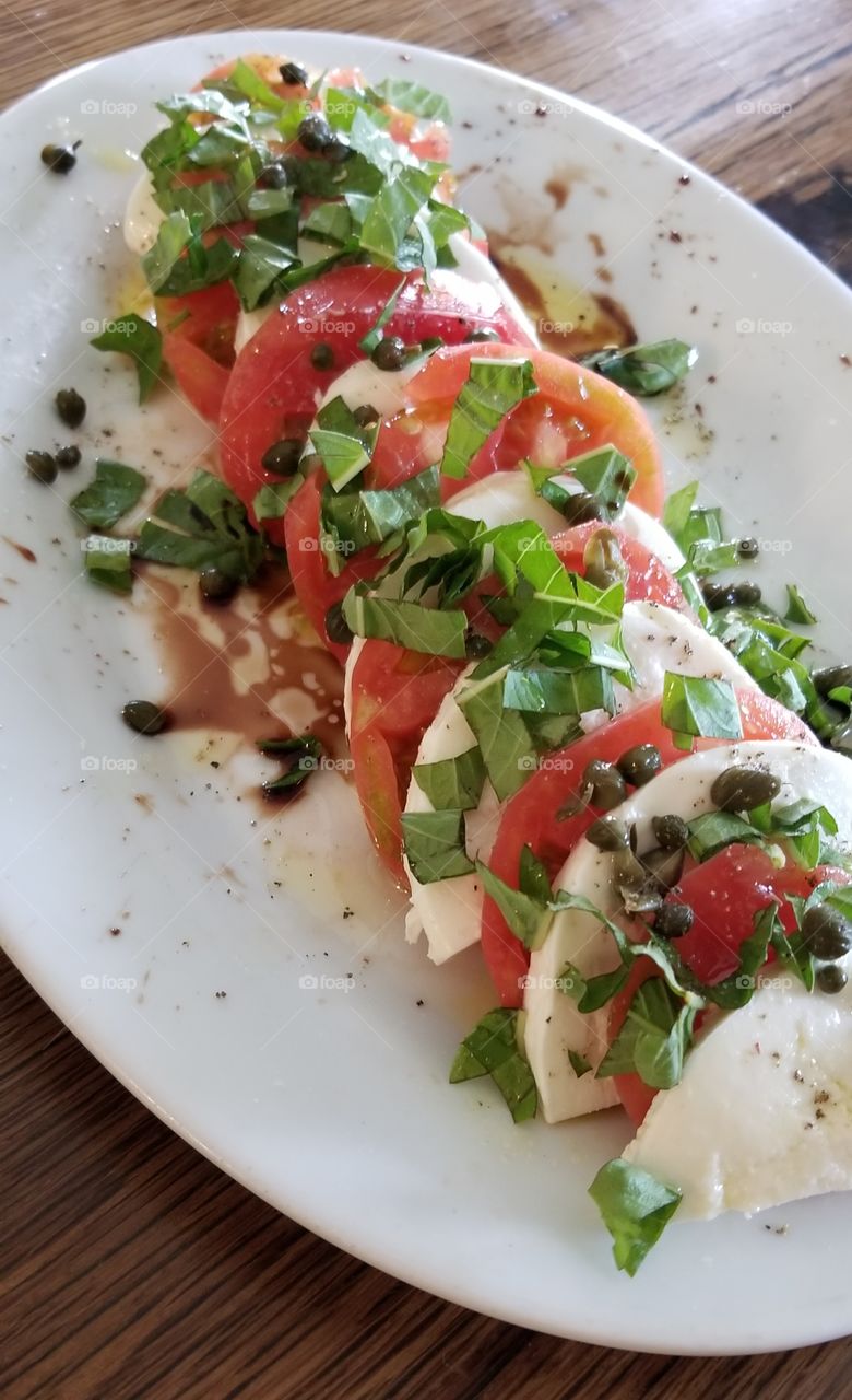 caprese salad with tomato, mozzarella, and basil from the garden