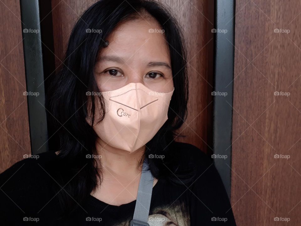 Asian woman's sharp gaze with a trending face mask