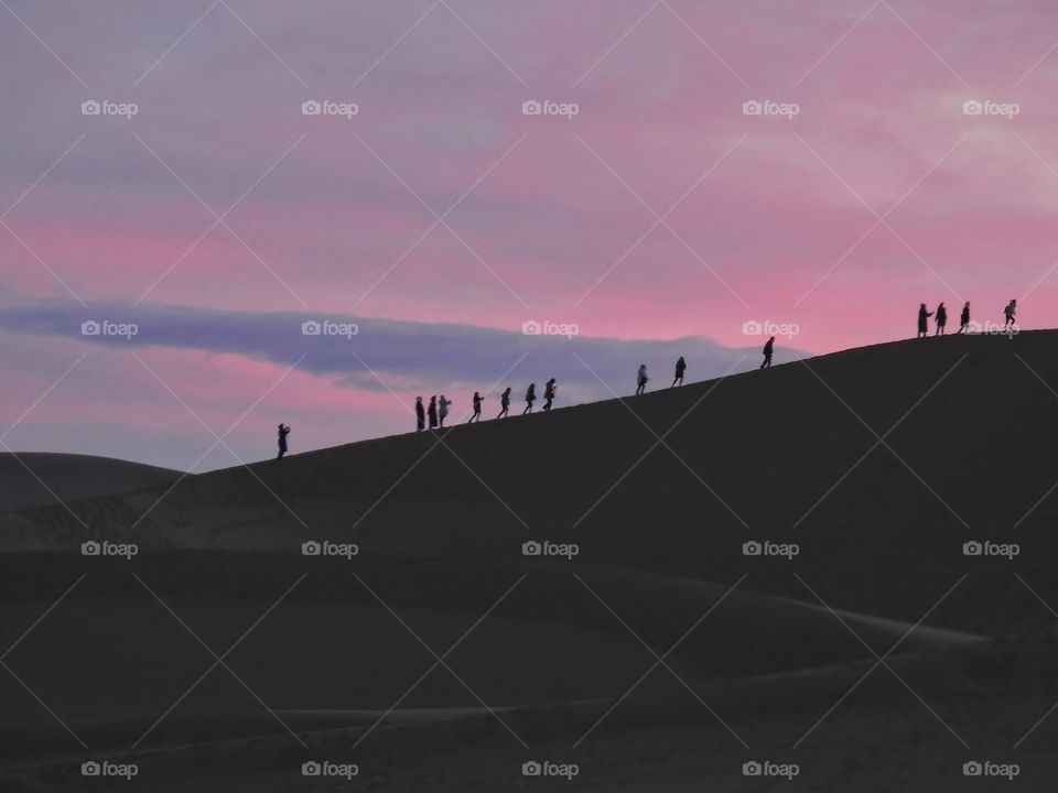 View of persons walking on a dune in the Moroccan desert