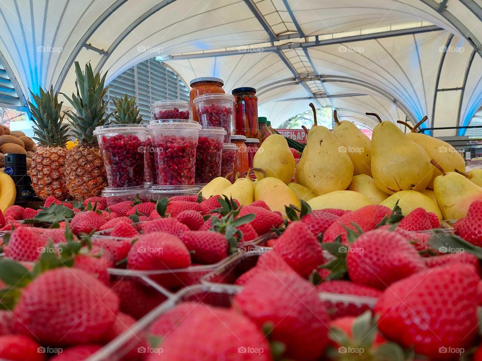 Details from the market: strawberries,  pears, pomegranate, and pineapple. Decorative ceiling in geometric shapes