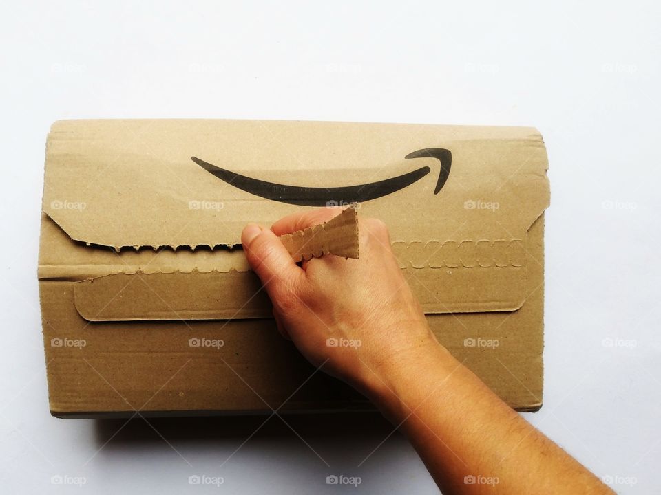 Hand opens an Amazon package