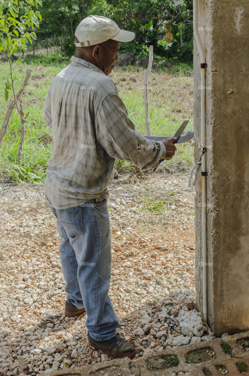 Man Sharpening Machete (Natural light only)