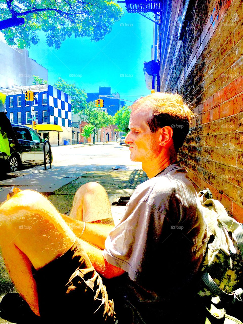 Timothy is sitting on the sidewalk of Waverly Street in Brooklyn, New York on an exceptionally bright, sunny and hot afternoon in the summer of 2020. In the background you can see Fulton Street. Hypnotic Productions