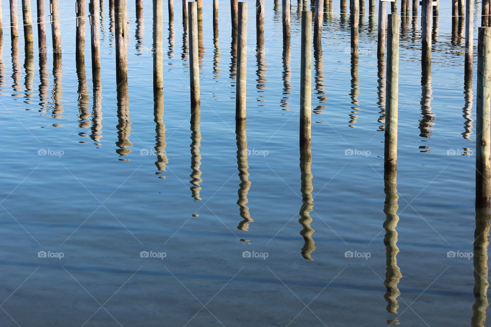 Wooden poles reflecting in water 