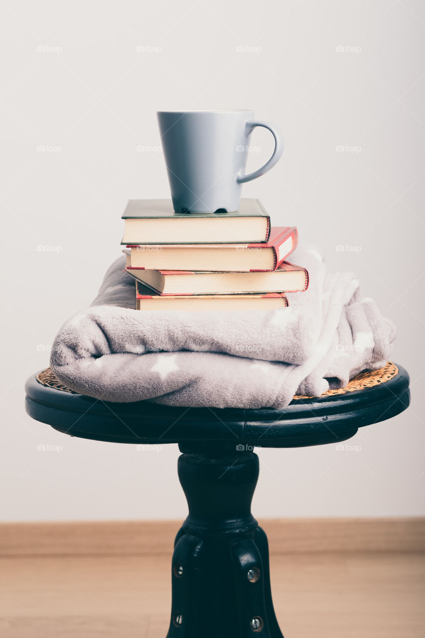 A few books with cup of coffee and blanket. Cozy and comfortable. Time for relax. Spending leisure time on reading. Learning from books. Studying for the next exams
