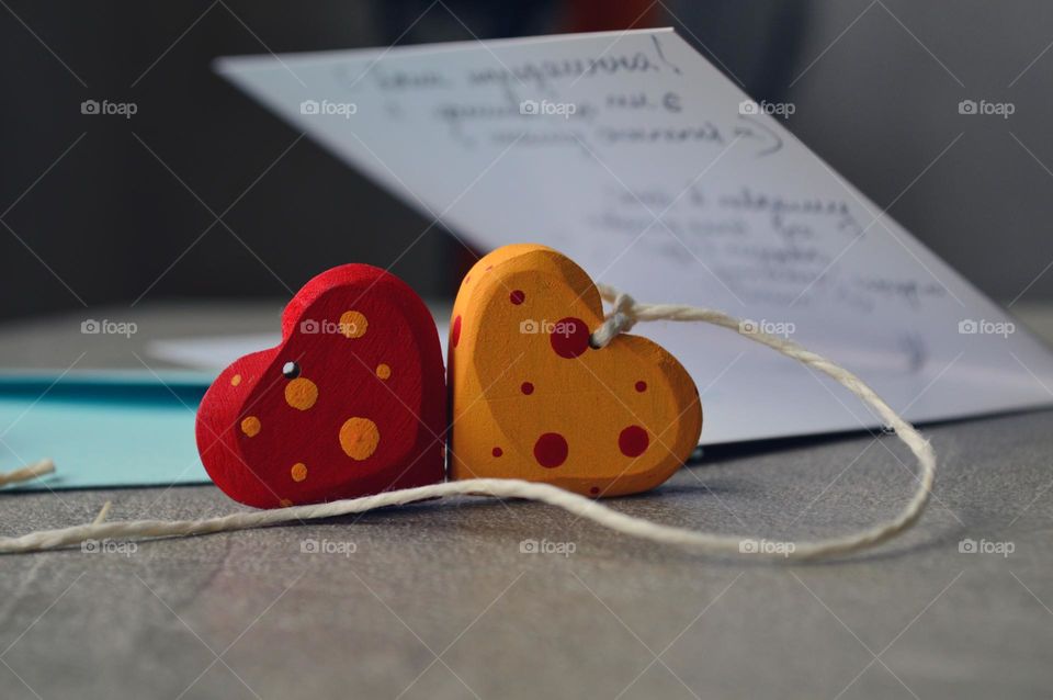 Multicolored wooden hearts near a greeting card