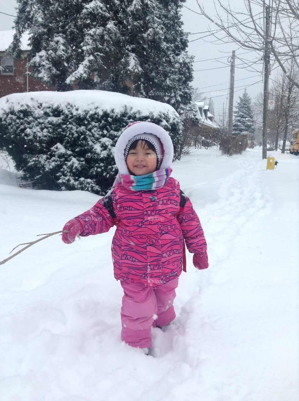 Cute little girl is playing outside enjoying the snow