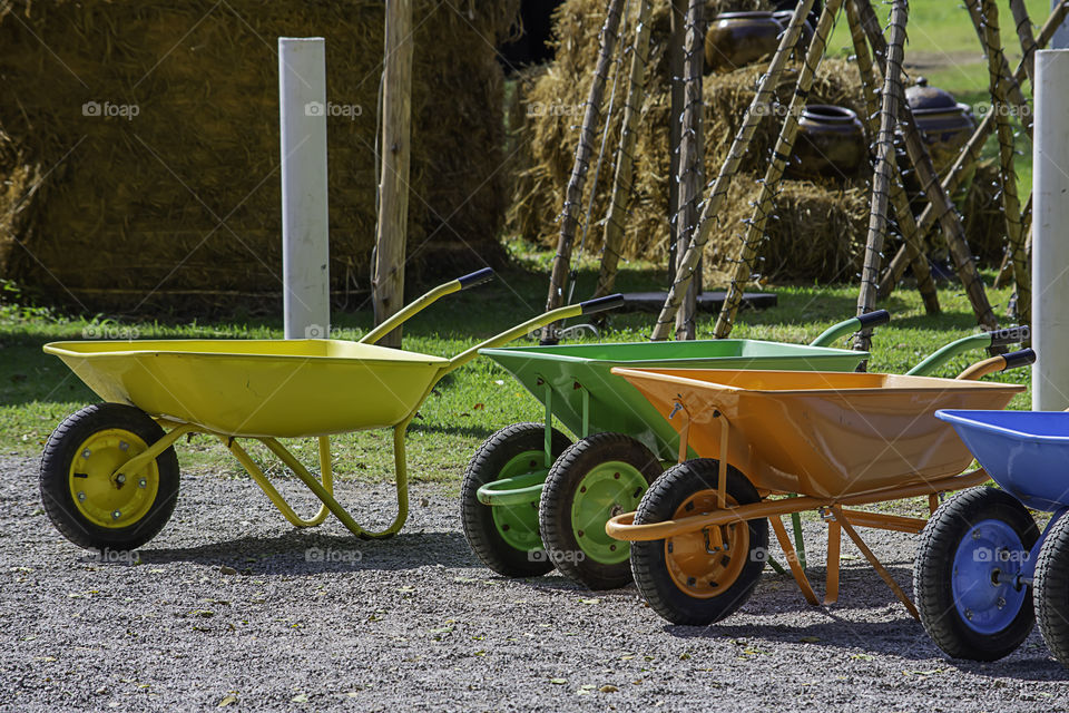 wheelbarrow carts colorful material on the floor.