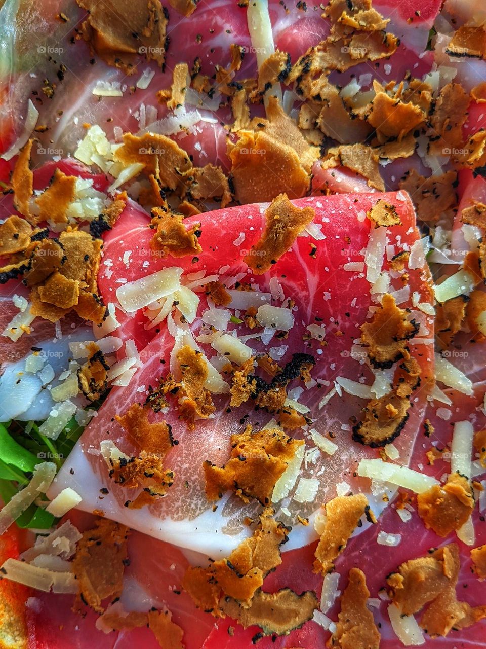 Top view of grilled pizza with bacon, cheese and vegetables on the plate close-up