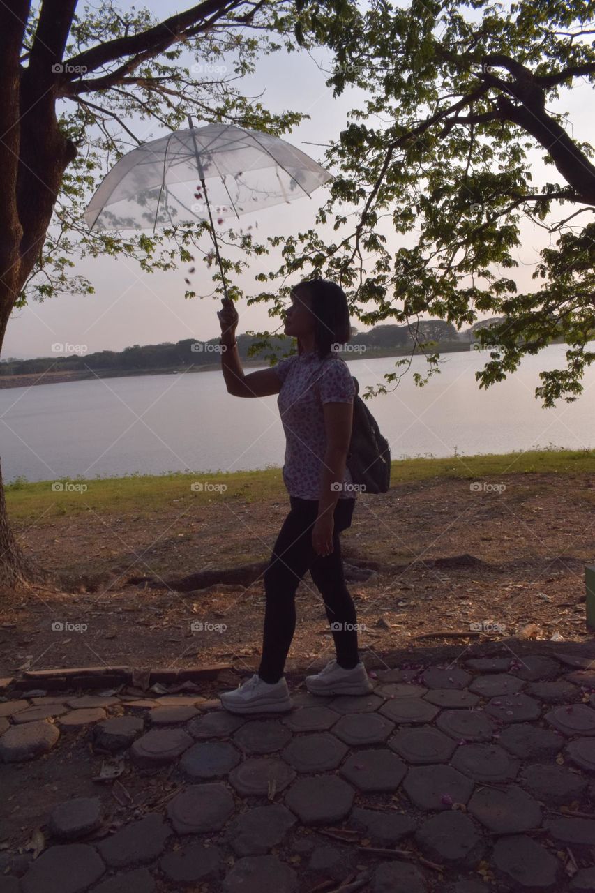 It wasn't raining, nor was the weather hot, but this woman was walking with an umbrella.