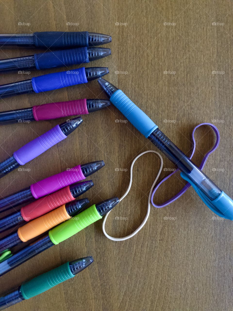 Colorful pens and rubber bands on drafting table 