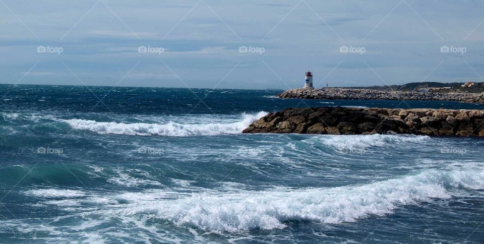 blue sea with a lighthouse in the background