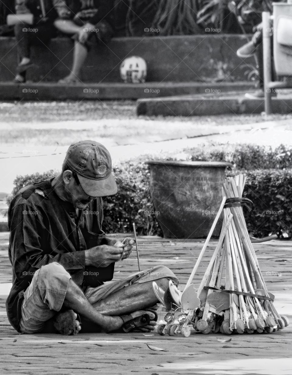 Toy seller sitting on street