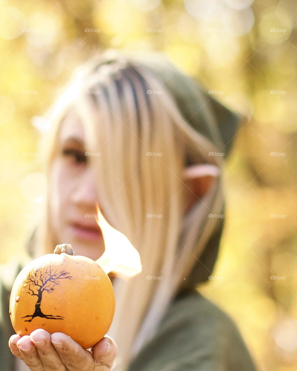 Cloaked Elf holding a flaming pumpkin