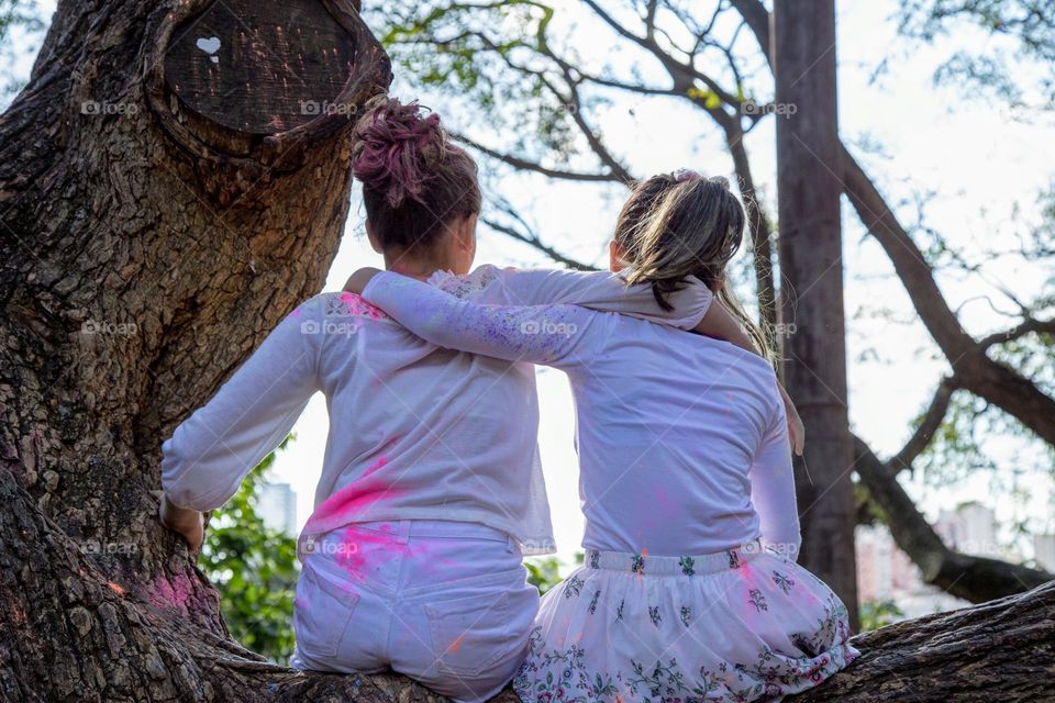 Two girls hugging on top of the tree