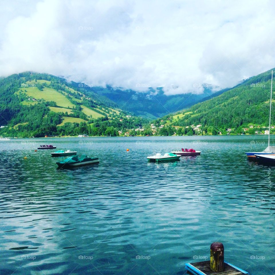 A view to Zell am See on a cloudy Summer day and some boats 