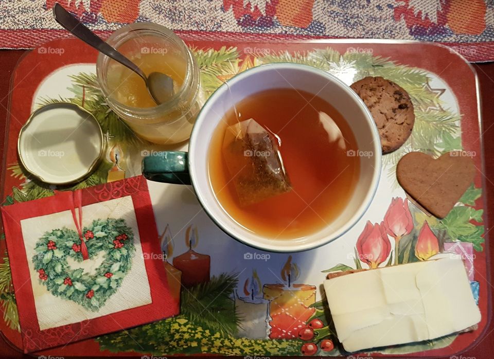 a cup of tea with a sandwich and cookies