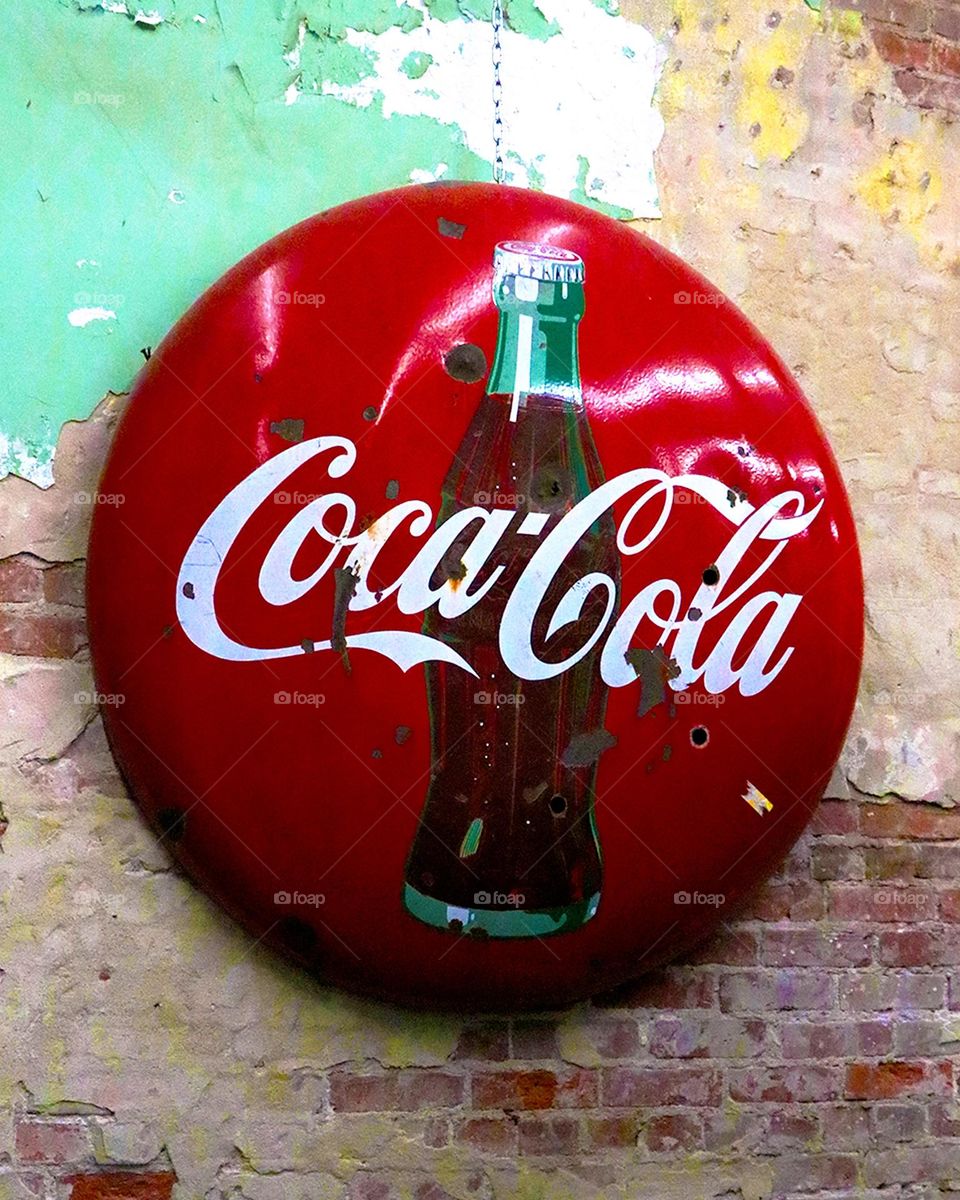 Vintage Coca Cola sign hangs on the wall