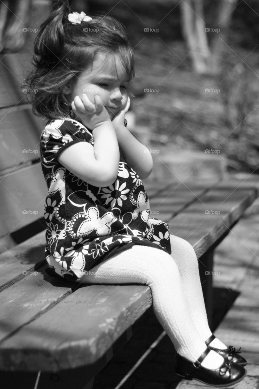 young girl sitting on a park bench