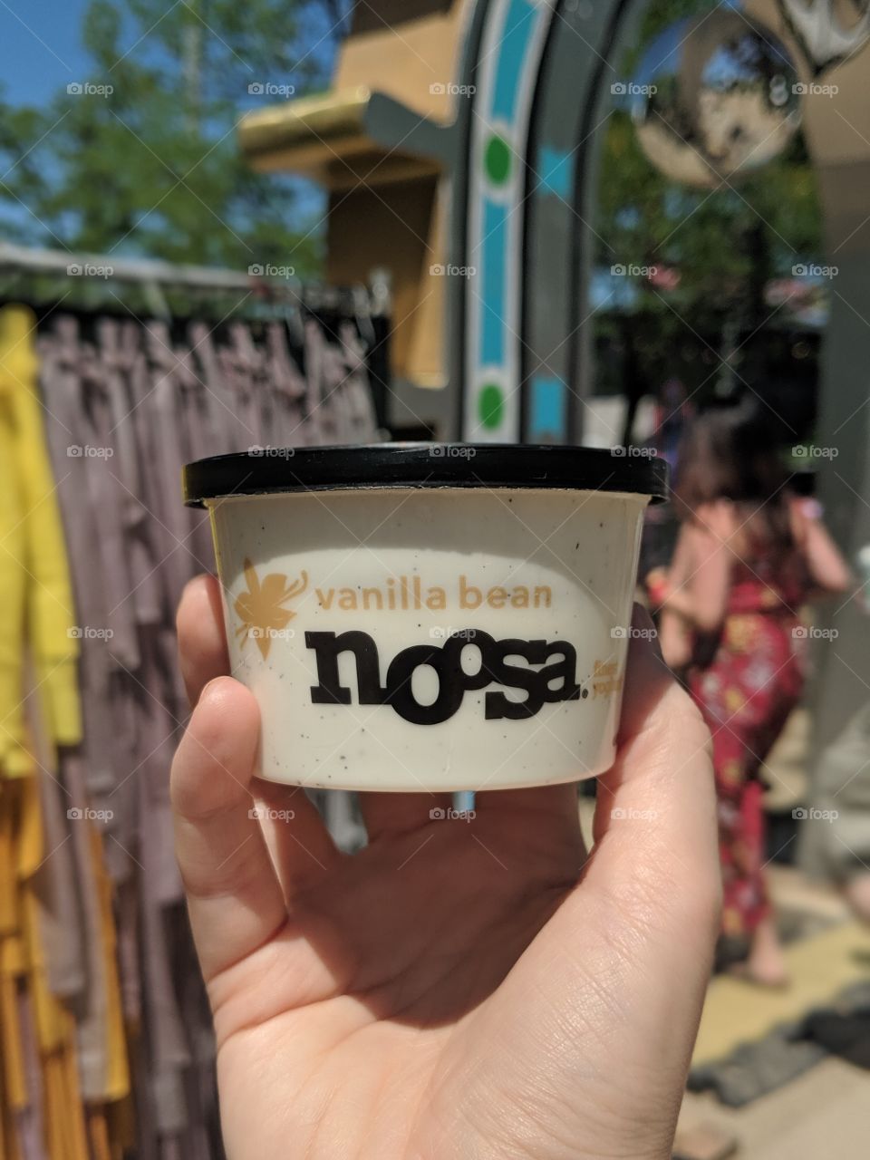 Hand holding Noosa yogurt