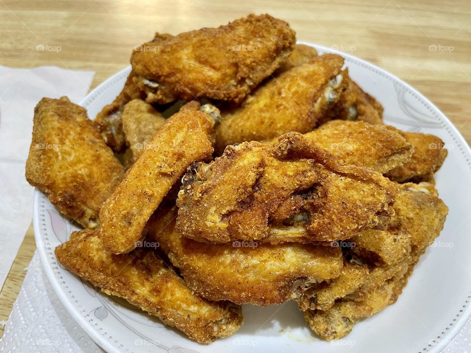 Golden Brown Crispy Fried Chicken Wings on a White Plate