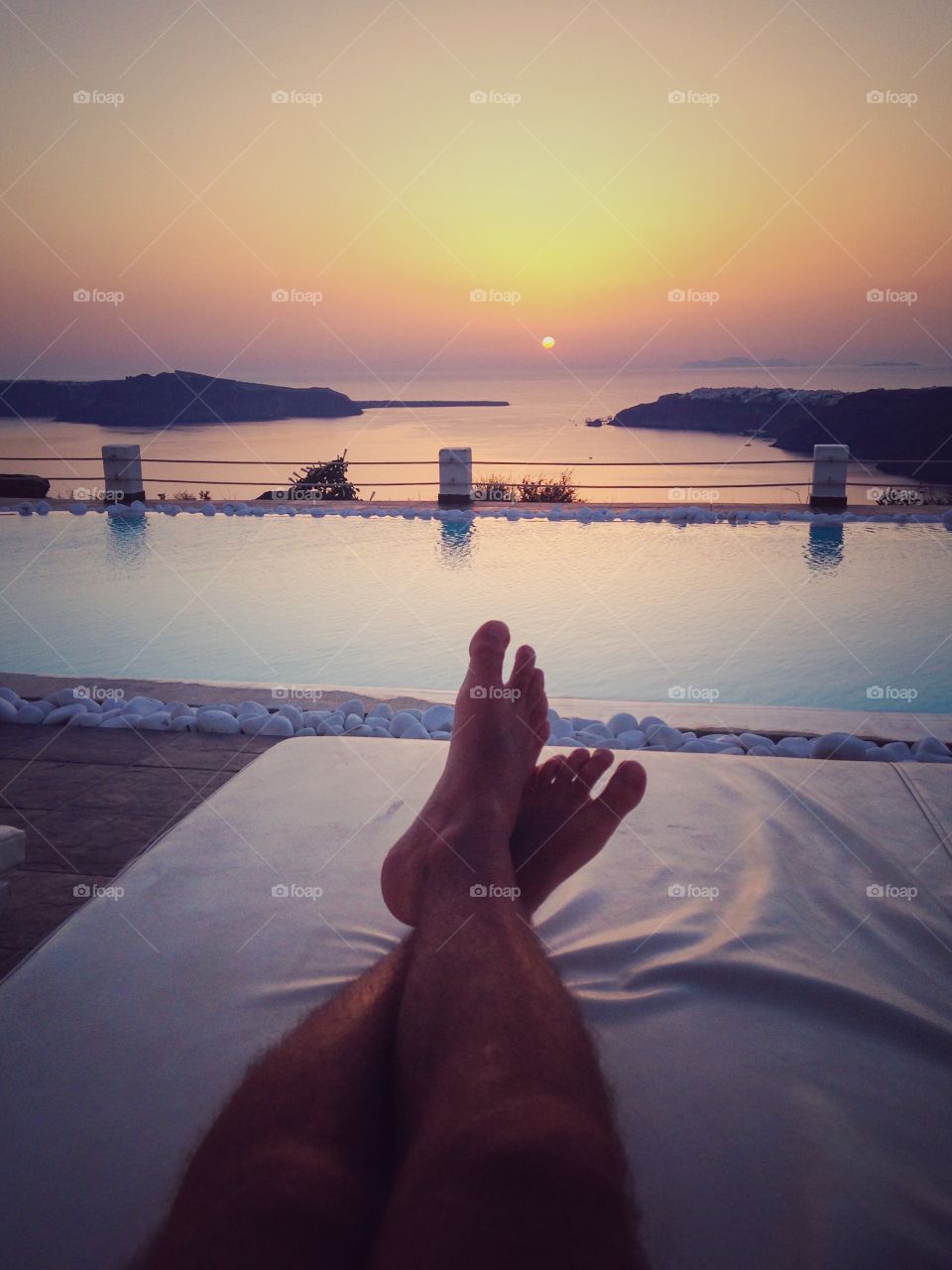 Man relaxing on sun lounge taking in the sunset. 