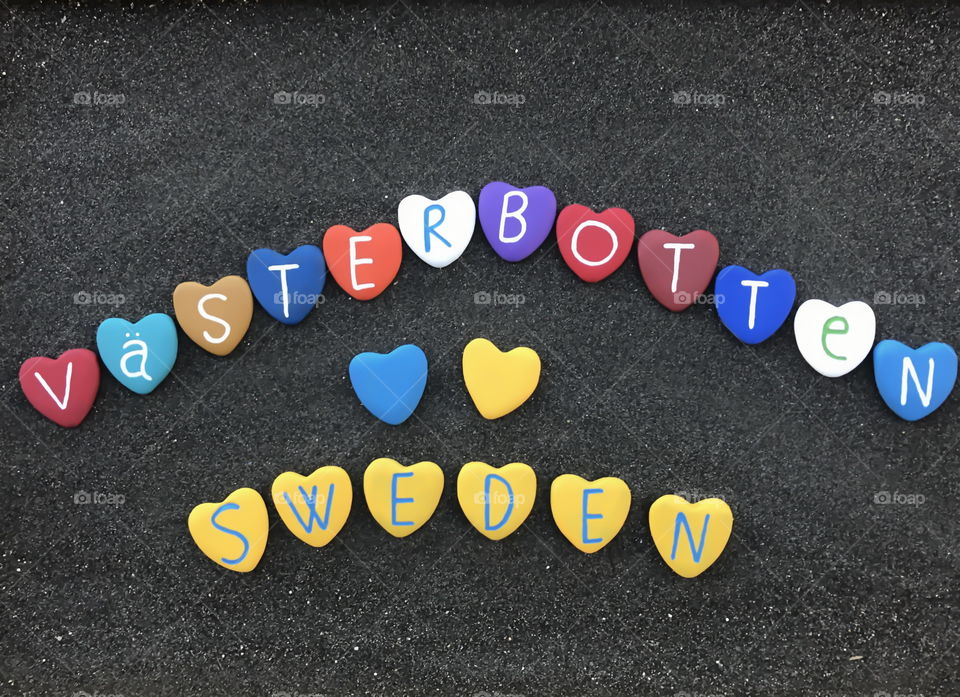 Västerbotten County, Sweden, souvenir with colored heart stones over black sand 
