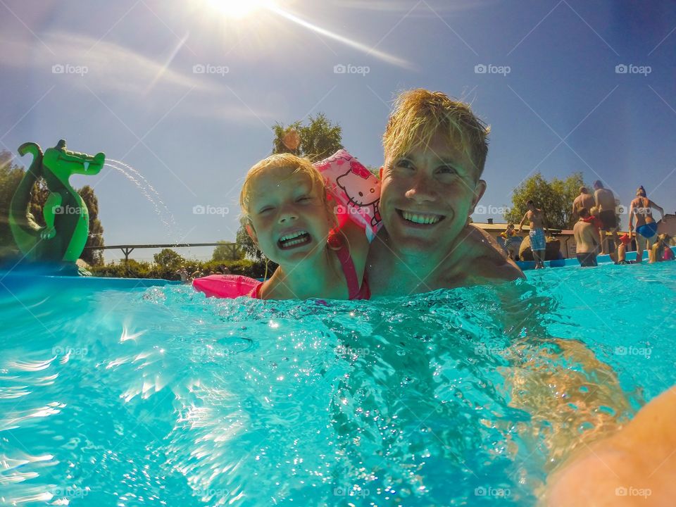 Father and daughter enjoying in swimming pool