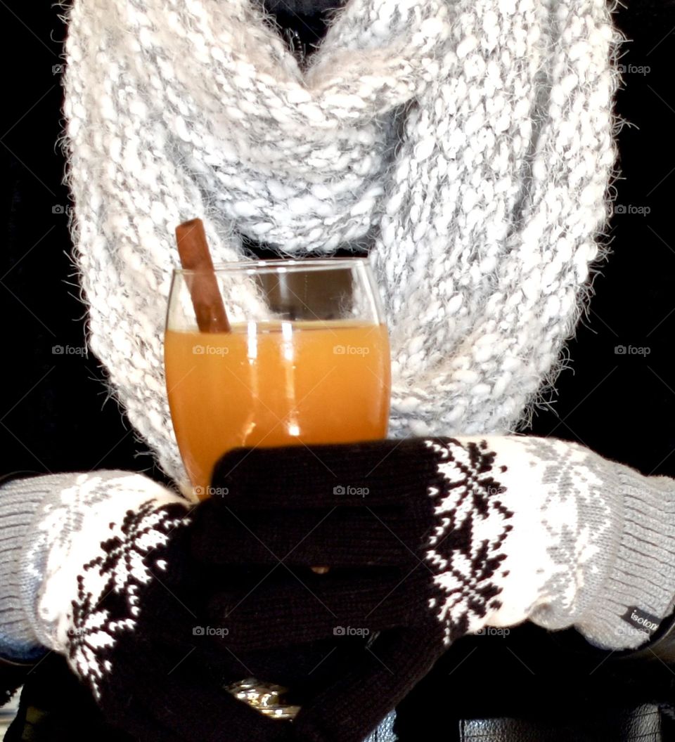 Woman holding hot cider with cinnamon stick