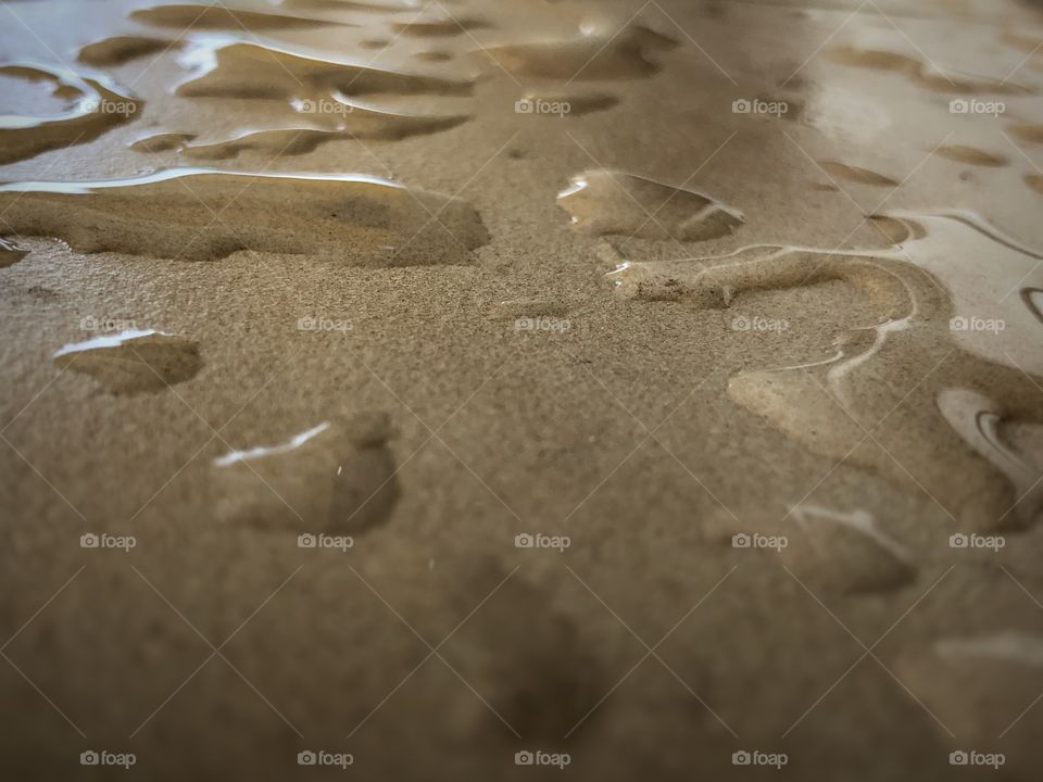 Water on a flat surface... Result of a rainy day. Closeup on a window’s base after the rain.