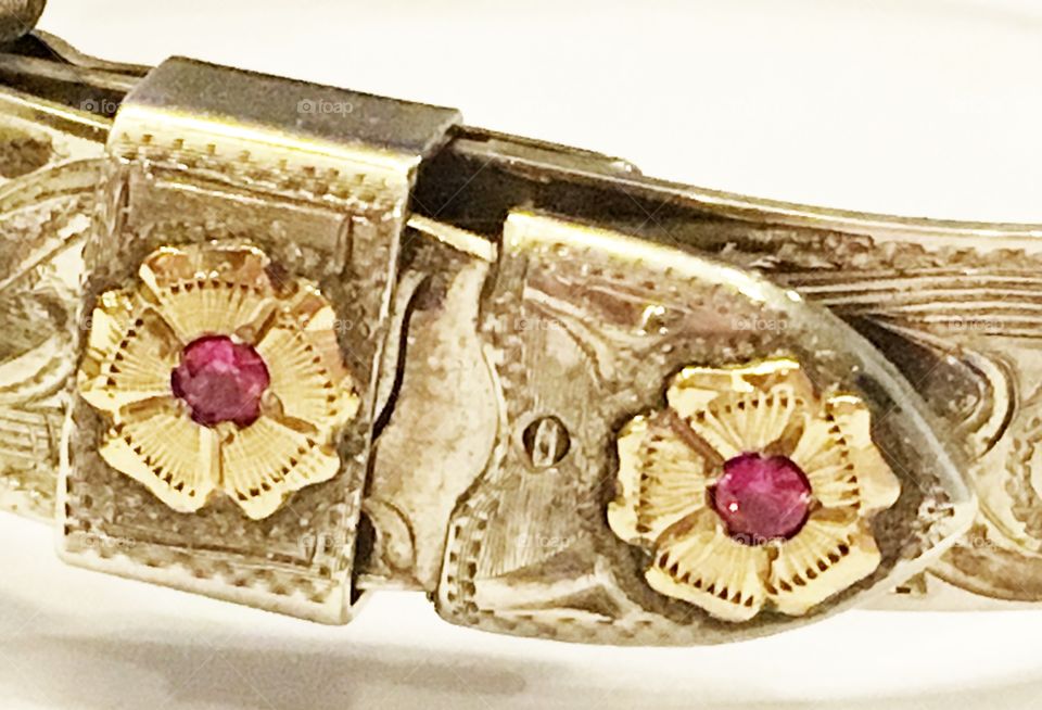 Close-up of a hand crafted bracelet with rubies set in silver and gold. 