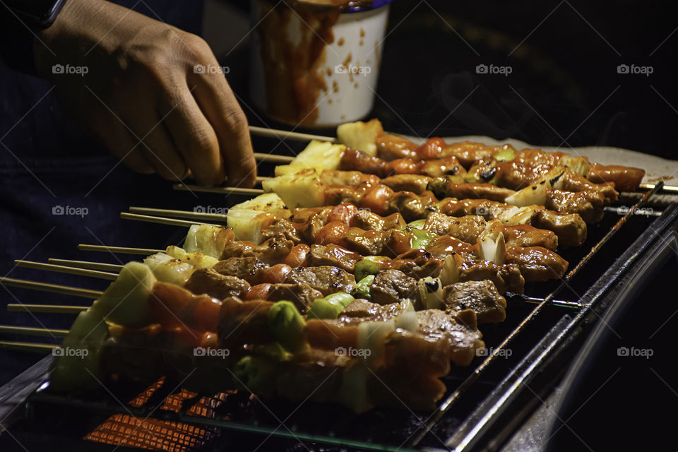 BBQ grilled meat with vegetables and tomato sauces on the steel grilles With the heat.