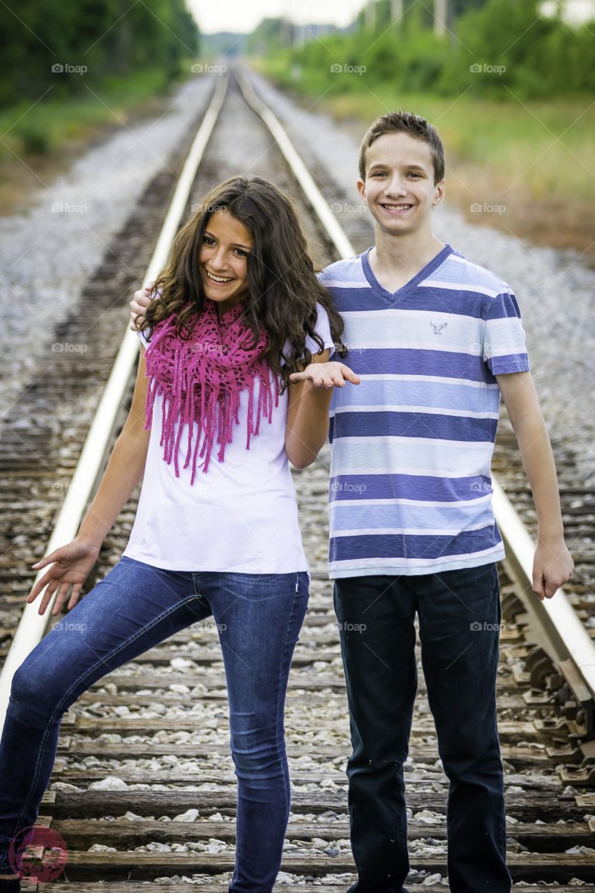 Siblings on a train track. Siblings on a train track being silly and laughing. 