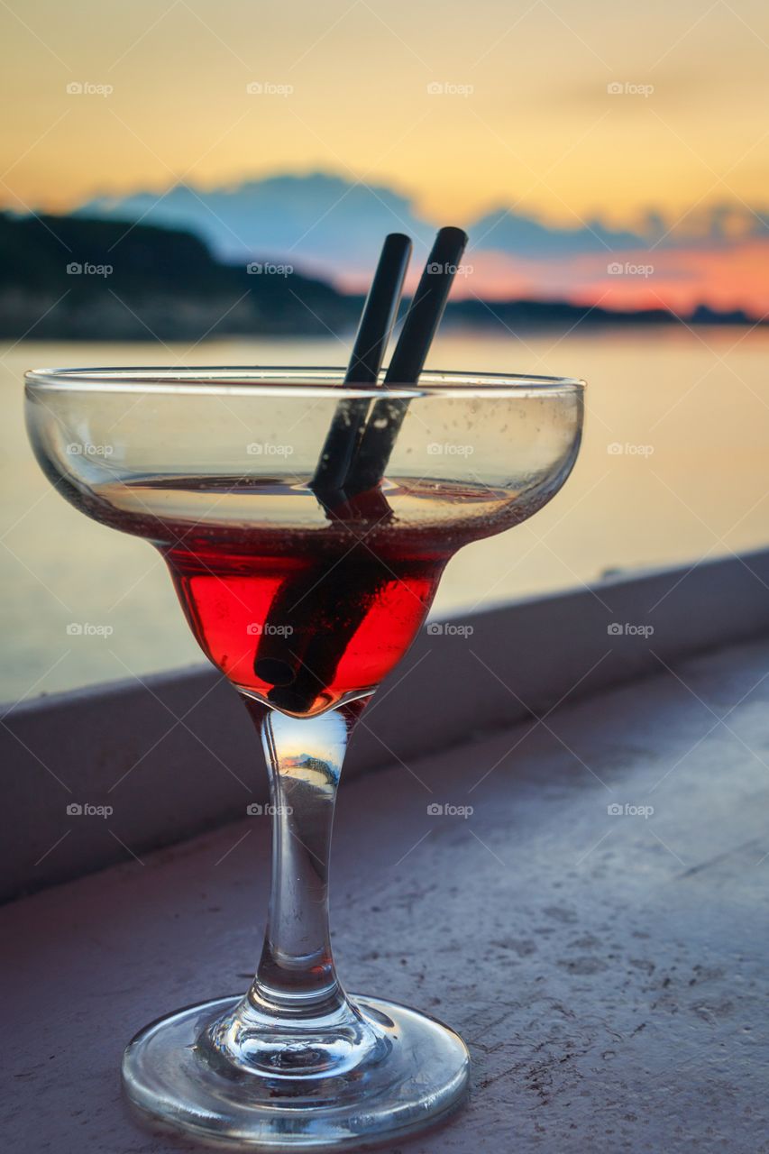 Cocktail at a bar by the sea at sunset