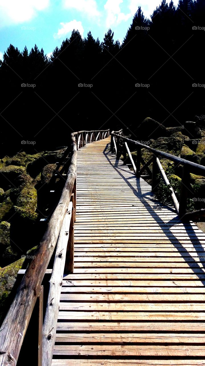 Beautiful wooden bridge over a river full of rocks