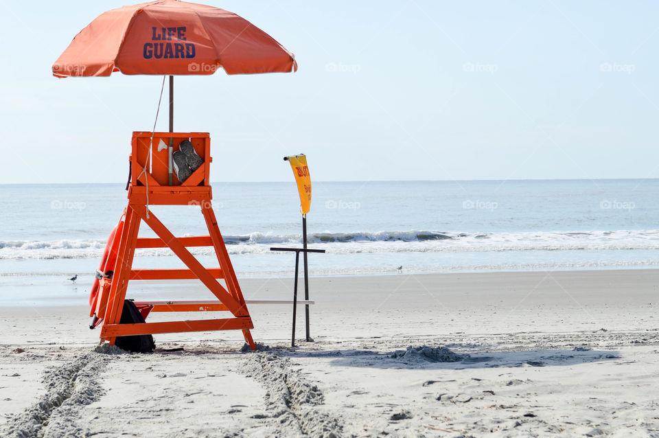 Empty lifeguard chair on the shore of the beach