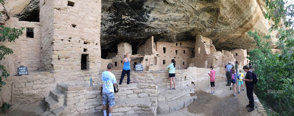 Tourists exploring a cliff dwelling at Mesa Verde National Park. 