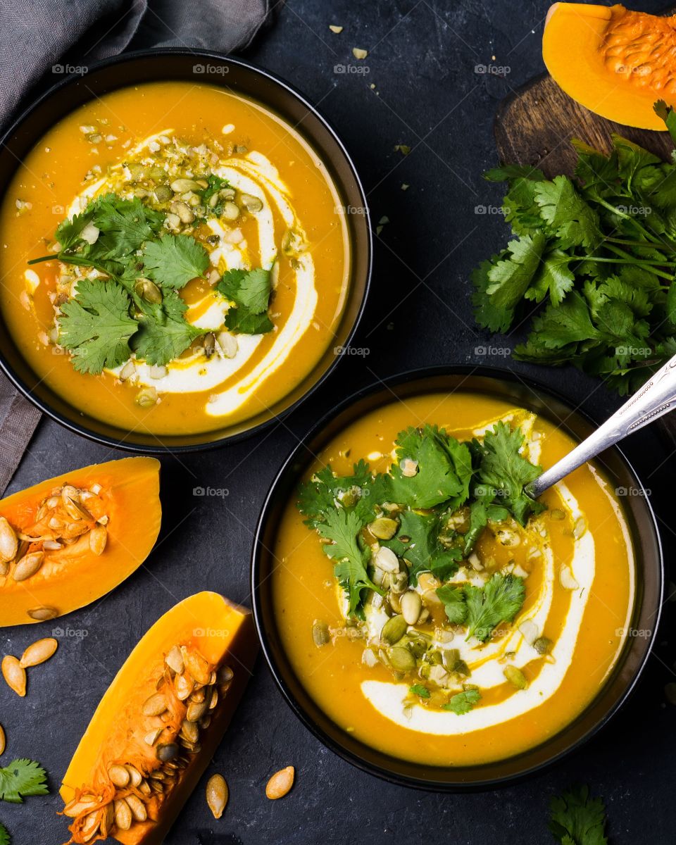 Two plates with pumpkin soup, top view